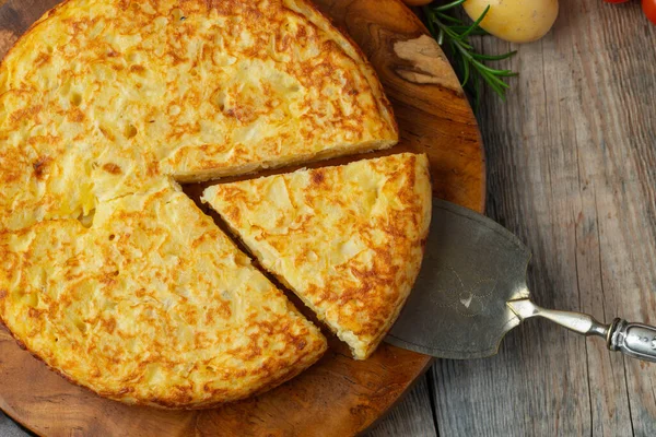 Spanisches Omelett mit Kartoffeln und Zwiebeln, typisch spanische Küche. Tortilla espanola. Rustikaler dunkler Hintergrund. Ansicht von oben — Stockfoto