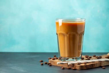 Büyük bardakta buzlu kahve, krema dökülmüş ve kahve çekirdekleri arka planda. Borularla soğuk yaz içkisi. Kopyalama alanı ile