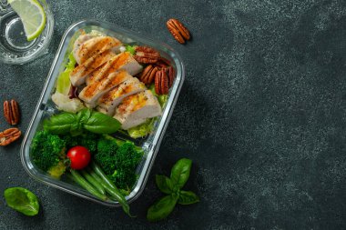 Taze fasulye, tavuk göğsü ve brokoli ile sağlıklı yemek hazırlama kapları. Koyu beton arka planda, beslenme çantasında Keto diyeti için bir set yiyecek. Kopyalama alanı olan üst görünüm.