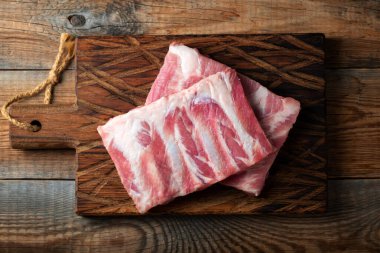 Çiğ Domuz kaburga ile baharat, tuz ve koyu ahşap zemin üzerine biberiye.