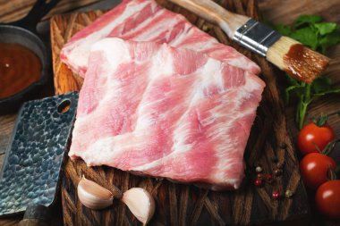 Çiğ Domuz kaburga ile baharat, tuz ve koyu ahşap zemin üzerine biberiye.