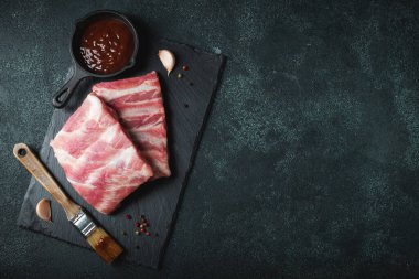 Çiğ et. Sırtından çiğ domuz kaburgası ve siyah bir arka planda et. arkaplan resmi, boşluk metni kopyala