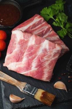 Çiğ et. Sırtından çiğ domuz kaburgası ve siyah bir arka planda et. arkaplan resmi, boşluk metni kopyala