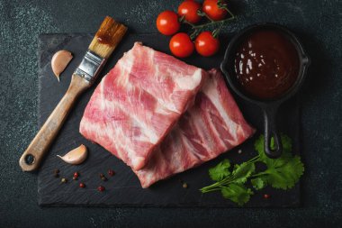 Çiğ et. Sırtından çiğ domuz kaburgası ve siyah bir arka planda et. arkaplan resmi, boşluk metni kopyala