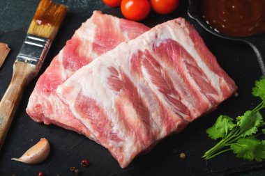 Çiğ et. Sırtından çiğ domuz kaburgası ve siyah bir arka planda et. arkaplan resmi, boşluk metni kopyala