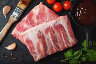 Çiğ et. Sırtından çiğ domuz kaburgası ve siyah bir arka planda et. arkaplan resmi, boşluk metni kopyala