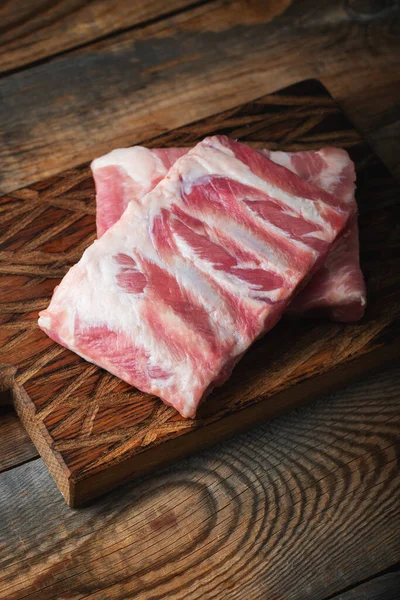 Çiğ Domuz kaburga ile baharat, tuz ve koyu ahşap zemin üzerine biberiye.
