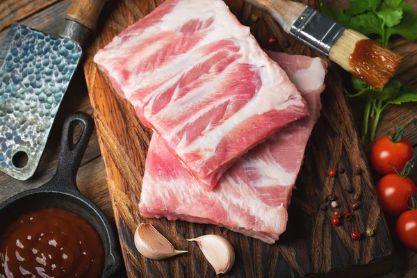 Çiğ Domuz kaburga ile baharat, tuz ve koyu ahşap zemin üzerine biberiye.