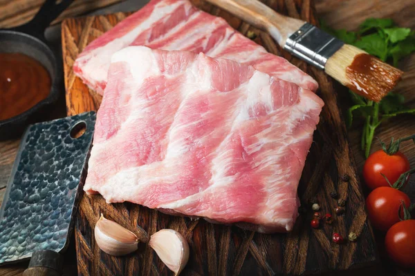 Çiğ Domuz kaburga ile baharat, tuz ve koyu ahşap zemin üzerine biberiye.