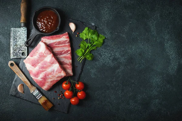 Çiğ et. Sırtından çiğ domuz kaburgası ve siyah bir arka planda et. arkaplan resmi, boşluk metni kopyala