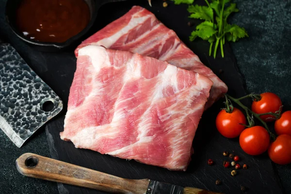 Çiğ et. Sırtından çiğ domuz kaburgası ve siyah bir arka planda et. arkaplan resmi, boşluk metni kopyala