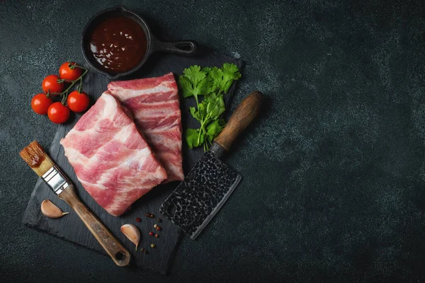 Çiğ et. Sırtından çiğ domuz kaburgası ve siyah bir arka planda et. arkaplan resmi, boşluk metni kopyala
