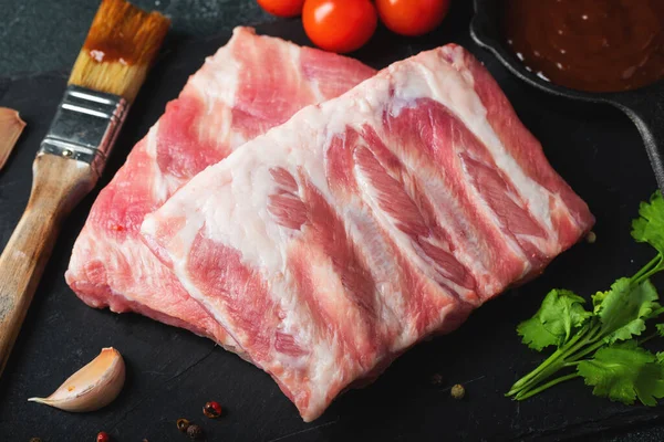 Çiğ et. Sırtından çiğ domuz kaburgası ve siyah bir arka planda et. arkaplan resmi, boşluk metni kopyala