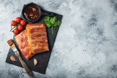 Barbekü, çiğ domuz pirzolası ve barbekü sosu hazır. Siyah arka plan. Üst görünüm.