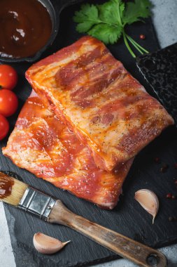 Barbekü, çiğ domuz pirzolası ve barbekü sosu hazır. Siyah arka plan. Üst görünüm.