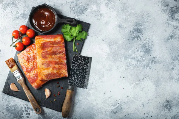 Barbekü, çiğ domuz pirzolası ve barbekü sosu hazır. Siyah arka plan. Üst görünüm.