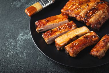 Barbekü soslu bir tabakta servis edilen sıcak ızgara pirzola. Üst Manzara. Boşluğu kopyala.