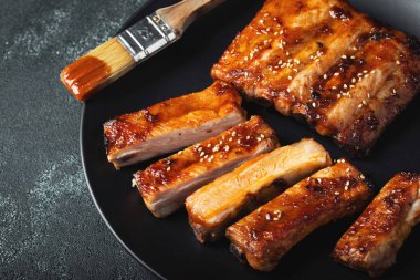 Barbekü soslu bir tabakta servis edilen sıcak ızgara pirzola. Üst Manzara. Boşluğu kopyala.