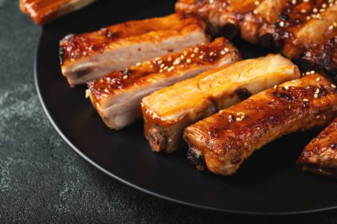 Barbekü soslu bir tabakta servis edilen sıcak ızgara pirzola. Üst Manzara. Boşluğu kopyala.