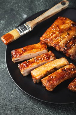 Barbekü soslu bir tabakta servis edilen sıcak ızgara pirzola. Üst Manzara. Boşluğu kopyala.