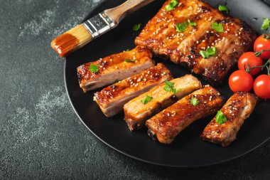 Barbekü soslu bir tabakta servis edilen sıcak ızgara pirzola. Üst Manzara. Boşluğu kopyala.