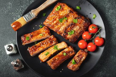 Barbekü soslu bir tabakta servis edilen sıcak ızgara pirzola. Üst Manzara. Boşluğu kopyala.