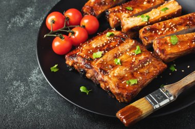 Barbekü soslu bir tabakta servis edilen sıcak ızgara pirzola. Üst Manzara. Boşluğu kopyala.