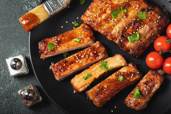 Barbekü soslu bir tabakta servis edilen sıcak ızgara pirzola. Üst Manzara. Boşluğu kopyala.