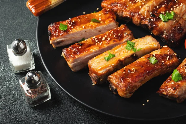 Barbekü soslu bir tabakta servis edilen sıcak ızgara pirzola. Üst Manzara. Boşluğu kopyala.