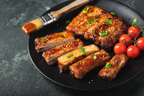 Barbekü soslu bir tabakta servis edilen sıcak ızgara pirzola. Üst Manzara. Boşluğu kopyala.