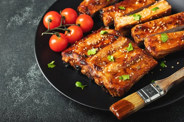 Barbekü soslu bir tabakta servis edilen sıcak ızgara pirzola. Üst Manzara. Boşluğu kopyala.