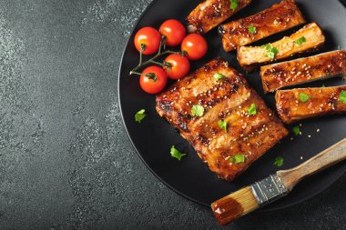 Barbekü soslu bir tabakta servis edilen sıcak ızgara pirzola. Üst Manzara. Boşluğu kopyala.