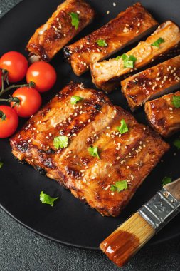 Barbekü soslu bir tabakta servis edilen sıcak ızgara pirzola. Üst Manzara. Boşluğu kopyala.