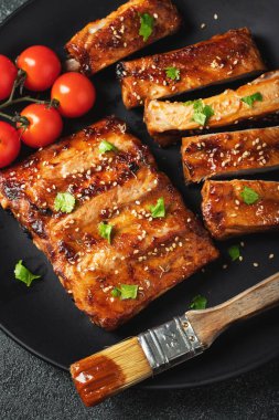 Barbekü soslu bir tabakta servis edilen sıcak ızgara pirzola. Üst Manzara. Boşluğu kopyala.