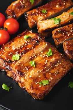 Barbekü soslu bir tabakta servis edilen sıcak ızgara pirzola. Üst Manzara. Boşluğu kopyala.