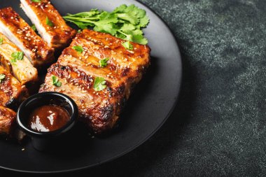 Barbekü soslu bir tabakta servis edilen sıcak ızgara pirzola. Üst Manzara. Boşluğu kopyala.