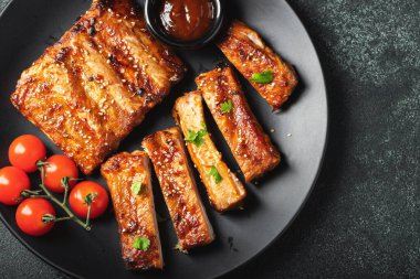 Barbekü soslu bir tabakta servis edilen sıcak ızgara pirzola. Üst Manzara. Boşluğu kopyala.