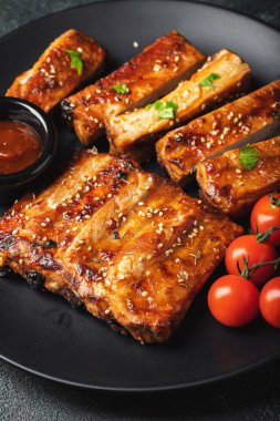 Barbekü soslu bir tabakta servis edilen sıcak ızgara pirzola. Üst Manzara. Boşluğu kopyala.