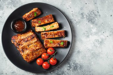 Barbekü soslu ızgara domuz pirzolası ve balda karamelize edilmiş. Hafif beton arka planda dosyalama yapmak için ahşap bir tahtada biraya lezzetli atıştırmalıklar. Kopyalama alanı olan üst görünüm.