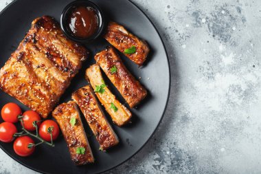 Barbekü soslu ızgara domuz pirzolası ve balda karamelize edilmiş. Hafif beton arka planda dosyalama yapmak için ahşap bir tahtada biraya lezzetli atıştırmalıklar. Kopyalama alanı olan üst görünüm.