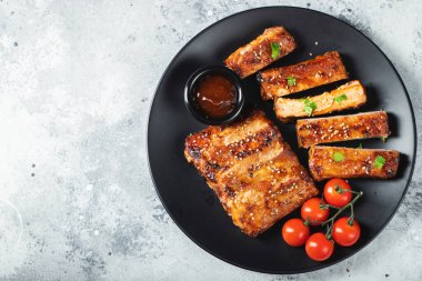 Barbekü soslu ızgara domuz pirzolası ve balda karamelize edilmiş. Hafif beton arka planda dosyalama yapmak için ahşap bir tahtada biraya lezzetli atıştırmalıklar. Kopyalama alanı olan üst görünüm.