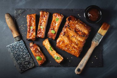 Barbekü domuz pirzolası ve siyah arka planda sıcak bal biberli terbiye..