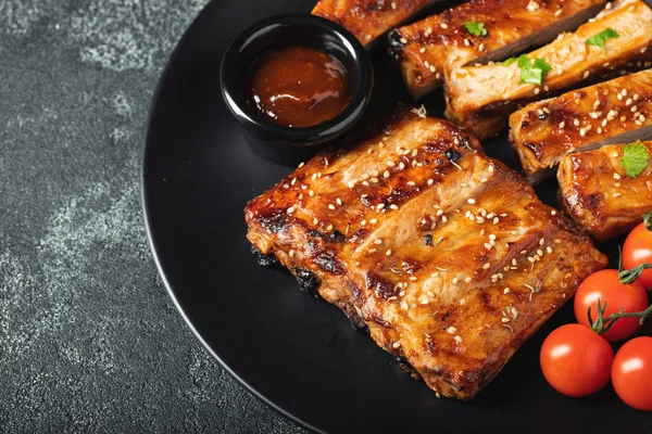 Barbekü soslu bir tabakta servis edilen sıcak ızgara pirzola. Üst Manzara. Boşluğu kopyala.