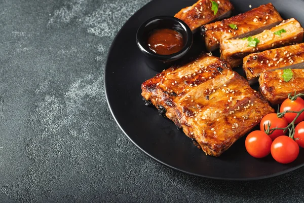 Barbekü soslu bir tabakta servis edilen sıcak ızgara pirzola. Üst Manzara. Boşluğu kopyala.