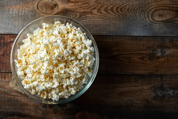 Ahşap arka planda patlamış mısır. Yemek ve atıştırmalık kavramları. En düşük görünüm modeli. Kopyalama alanı olan üst görünüm