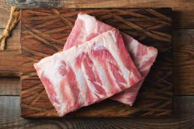 Çiğ Domuz kaburga ile baharat, tuz ve koyu ahşap zemin üzerine biberiye.