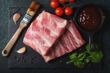 Çiğ et. Sırtından çiğ domuz kaburgası ve siyah bir arka planda et. arkaplan resmi, boşluk metni kopyala