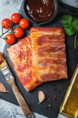 Barbekü, çiğ domuz pirzolası ve barbekü sosu hazır. Siyah arka plan. Üst görünüm.