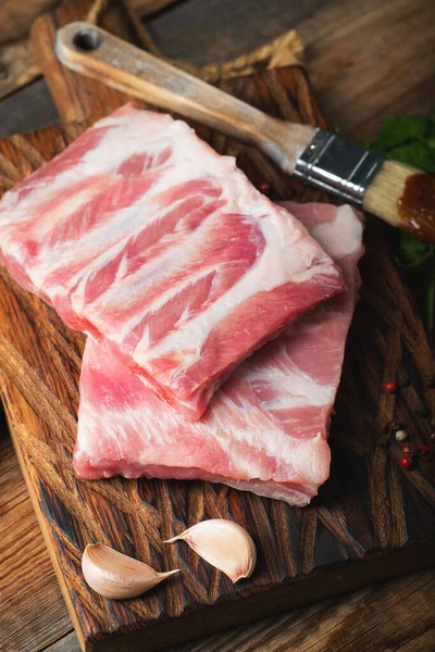Çiğ Domuz kaburga ile baharat, tuz ve koyu ahşap zemin üzerine biberiye.