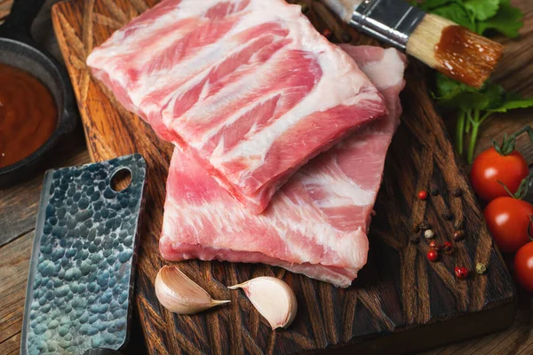Çiğ Domuz kaburga ile baharat, tuz ve koyu ahşap zemin üzerine biberiye.